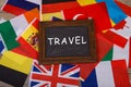 Travel - blackboard with text "Travel", flags of different countries on wooden background Royalty Free Stock Photo