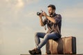 Travel blog. Man sit on suitcase. Handsome guy traveler retro camera. Guy outdoors with vintage suitcase