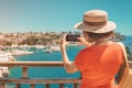 Travel blogger takes high-quality pictures of the sea coast in a small resort town while on vacation