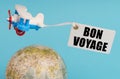 On a blue background, a globe and an airplane with a sign - Bon voyage Royalty Free Stock Photo