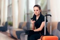 Woman Reading Phone Messages in Airport Waiting Room Royalty Free Stock Photo