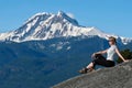 Travel Canada. Woman on mountain cliff against snow capped peak.