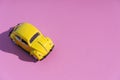 Travel car concept background. Yellow toy car on empty minimal pastel background. Driving, riding, road idea Royalty Free Stock Photo