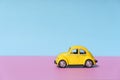 Travel car concept background. Yellow toy car on empty minimal pastel background. Driving, riding, road idea Royalty Free Stock Photo