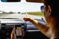 Travel in car concept, girl shows smartphone in her hand with opened gps navigation app Royalty Free Stock Photo