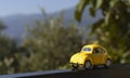 Travel car concept. Toy yellow car moves on against the backdrop of nature. Driving, adventure, discovery idea Royalty Free Stock Photo