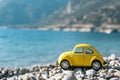 Travel car concept. Toy yellow car moves on against the backdrop of nature. Driving, adventure, discovery idea Royalty Free Stock Photo