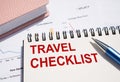 Travel Checklist text written on notepad with pen on financial documents Royalty Free Stock Photo