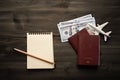 Travel concept with paper note book and pocket money on wood table background