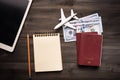 Travel concept with paper note book and pocket money on wood table background