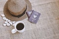 Travel concept, Close up a cup of black coffee, weave hat and Thai citizen passport