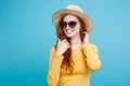 Travel concept - Close up Portrait young beautiful attractive redhair girl wtih trendy hat and sunglass smiling. Blue Royalty Free Stock Photo