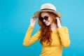 Travel concept - Close up Portrait young beautiful attractive redhair girl wtih trendy hat and sunglass smiling. Blue Royalty Free Stock Photo