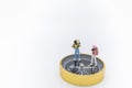 Travel Concept. Close up of two traveler miniature figure with backpack standing on compass on white background and copy space