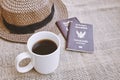 Travel concept, A cup of black coffee, weave hat and Thai citizen passport