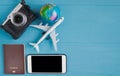 Travel Concept : Flat lay of vintage camera, smartphone, passport, golbe model and plane model, on blue wooden background, with c Royalty Free Stock Photo