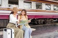 Travel concept. girl friend wear hat holding map have bag and luggage. female traveller waiting train at train station Royalty Free Stock Photo