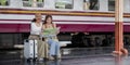 Travel concept. girl friend wear hat holding map have bag and luggage. female traveller waiting train at train station Royalty Free Stock Photo