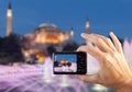 Travel concept. Hands making photo of night city with smartphone camera. Istanbul at sunset. Turkey Royalty Free Stock Photo