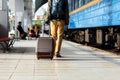 Travel concept. Men wear sneakers shoes and travel with luggage on the train station.