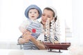 Travel concept. Mother and her child boy making model ship. Royalty Free Stock Photo