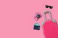 Travel concept. Pink travel suitcase, sunglasses, camera and passport with tickets on pink background. Copy space Royalty Free Stock Photo