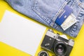 Travel concept with retro camera, passport, money, compass, clock and a white sheet for notes. Outfit of traveler on yellow Royalty Free Stock Photo