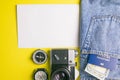 Travel concept with retro camera, passport, money, compass, clock and a white sheet for notes. Outfit of traveler on yellow Royalty Free Stock Photo