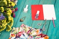 summer women set with dress, colorful flowers, cosmetics makeup, notepad, bijou and essentials on blue wooden background