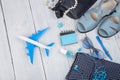 blue bag, sunglasses, sandals, nail polish, earphone note pad and little airplane on white wooden background Royalty Free Stock Photo