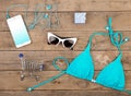 blue swimsuit, smart phone, sunglasses, headphones, gift box and shopping carts on brown wooden table