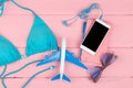 Travel concept - summer women& x27;s fashion with blue swimsuit, sunglasses, smart phone, headphones and little airplane Royalty Free Stock Photo