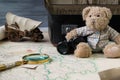 Travel concept, teddy bear with old binoculars and suitcase on the antique map with magnify glass Royalty Free Stock Photo