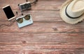 Top view of tourist accessories  on wooden table background camera ,hat ,passport, mobile phone,sunglasses. Royalty Free Stock Photo