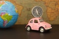Travel concept and vacations. Pink retro car with world globe sphere. Planning summer vacations Royalty Free Stock Photo