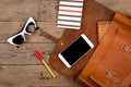 women set with bag, smart phone, sunglasses, notepad, pen and purse on brown wooden desk Royalty Free Stock Photo