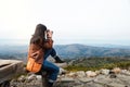 Travel Concept. Young Traveling Woman with Camera taking Photo