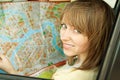 Young woman with road map in car during road trip Royalty Free Stock Photo