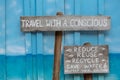 Travel with a conscious wooden sign on blue wooden background