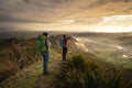 Travel couple standing at the peak of a mountain looking at the horizon. She is opening her arms Royalty Free Stock Photo