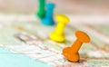 Travel destination points on a map indicated with colorful thumbtacks and shallow depth of field with space for copy