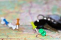 Travel destination points on a map indicated with colorful thumbtacks and shallow depth of field with space for copy. The keys to