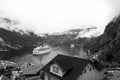 Travel destination, tourism. Ship in norwegian fjord on cloudy sky. Ocean liner in village harbor. Travel destination Royalty Free Stock Photo