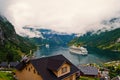 Travel destination, tourism. Ship in norwegian fjord on cloudy sky. Ocean liner in village harbor. Travel destination Royalty Free Stock Photo