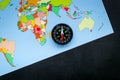 Travel direction and trip planning concept with compass and map of the world on black background top view Royalty Free Stock Photo