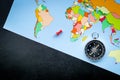 Travel direction and trip planning concept with compass and map of the world on black background top view space for text Royalty Free Stock Photo