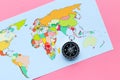 Travel direction and trip planning concept with compass and map of the world on pink background top view Royalty Free Stock Photo