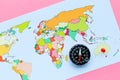 Travel direction and trip planning concept with compass and map of the world on pink background top view Royalty Free Stock Photo