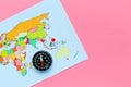 Travel direction and trip planning concept with compass and map of the world on pink background top view space for text Royalty Free Stock Photo