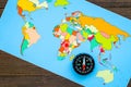 Travel direction and trip planning concept with compass and map of the world on wooden background top view Royalty Free Stock Photo